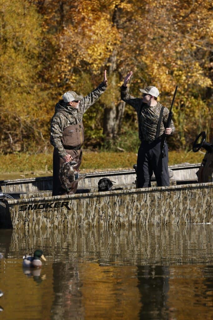 Two Guy's High Fiving In A Boat